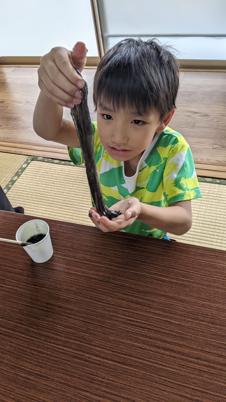 完成したスライムを伸ばして見せる子ども