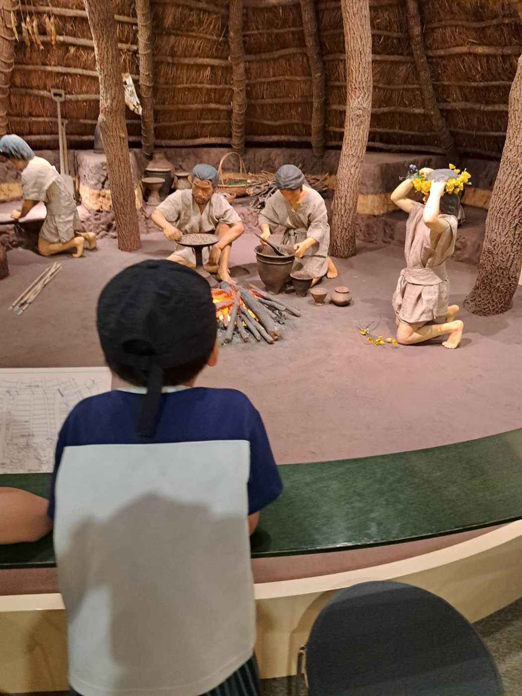竪穴住居の中のくらしを再現したジオラマを見る男の子
