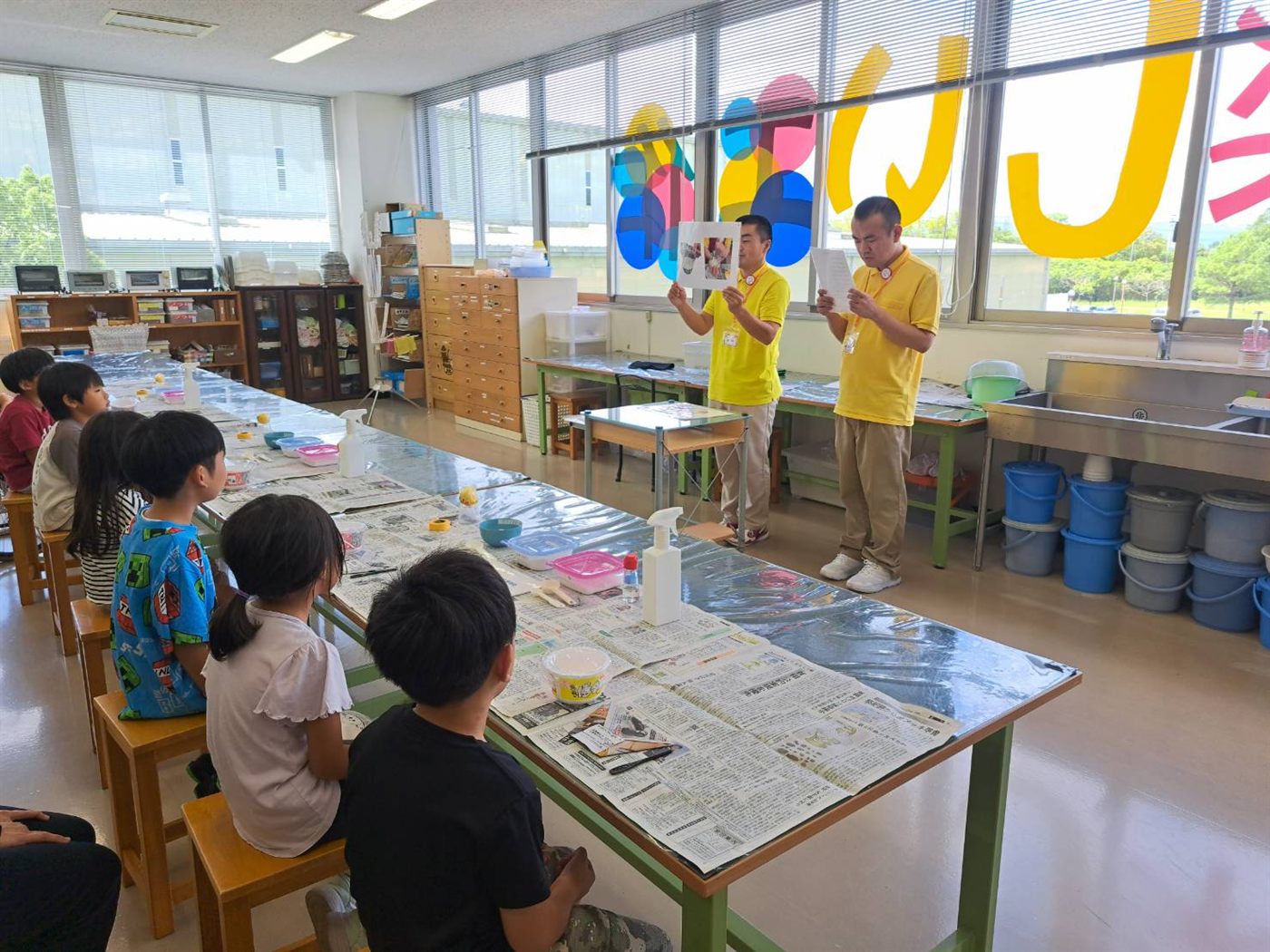 リサイクル工房でスタッフの説明を聞く子どもたち