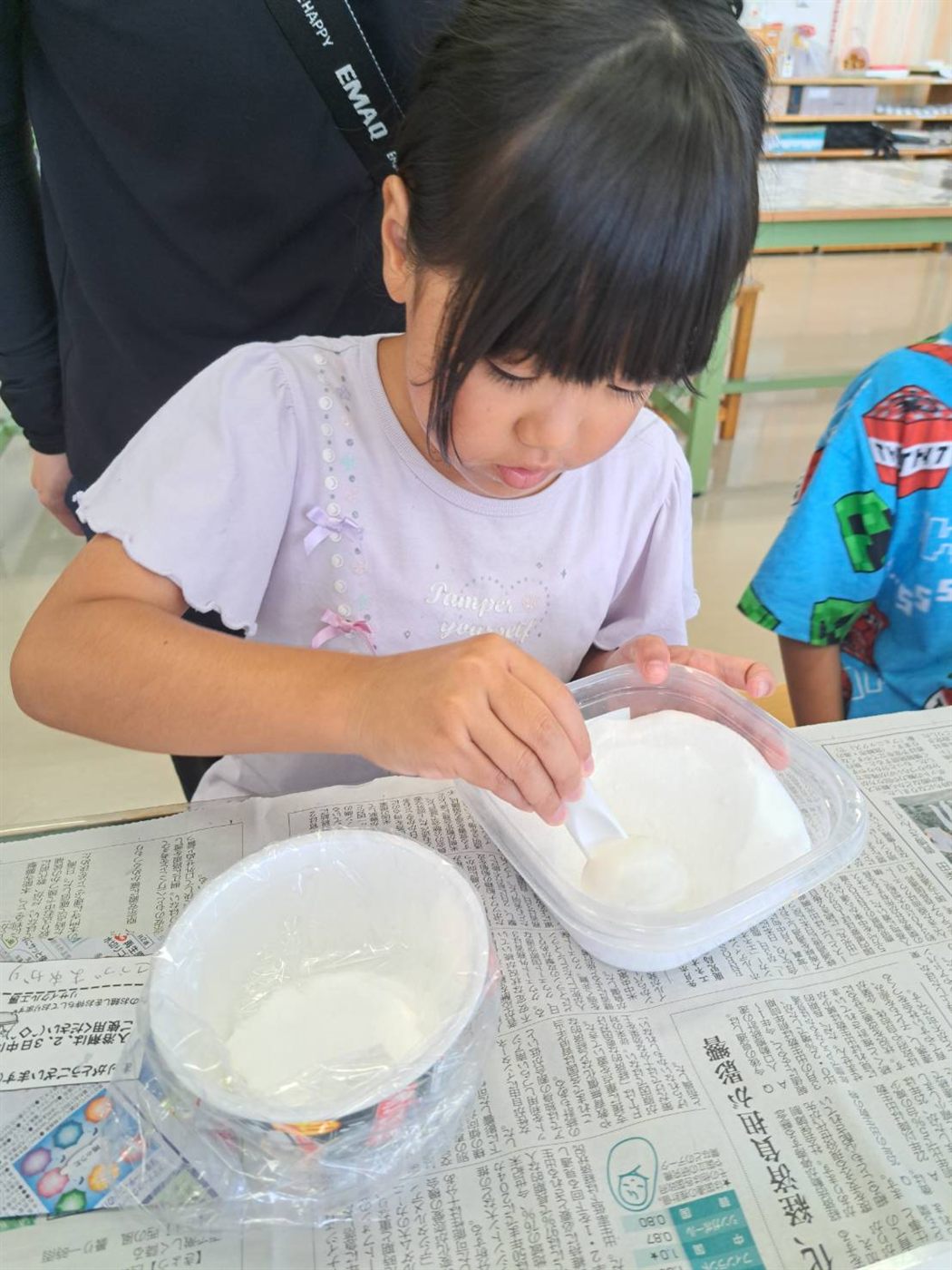 スプーンで粉をすくって計量する女の子