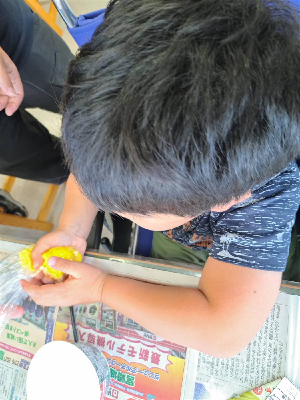 ラップで包んだバスボムをギュッと握って固める男の子