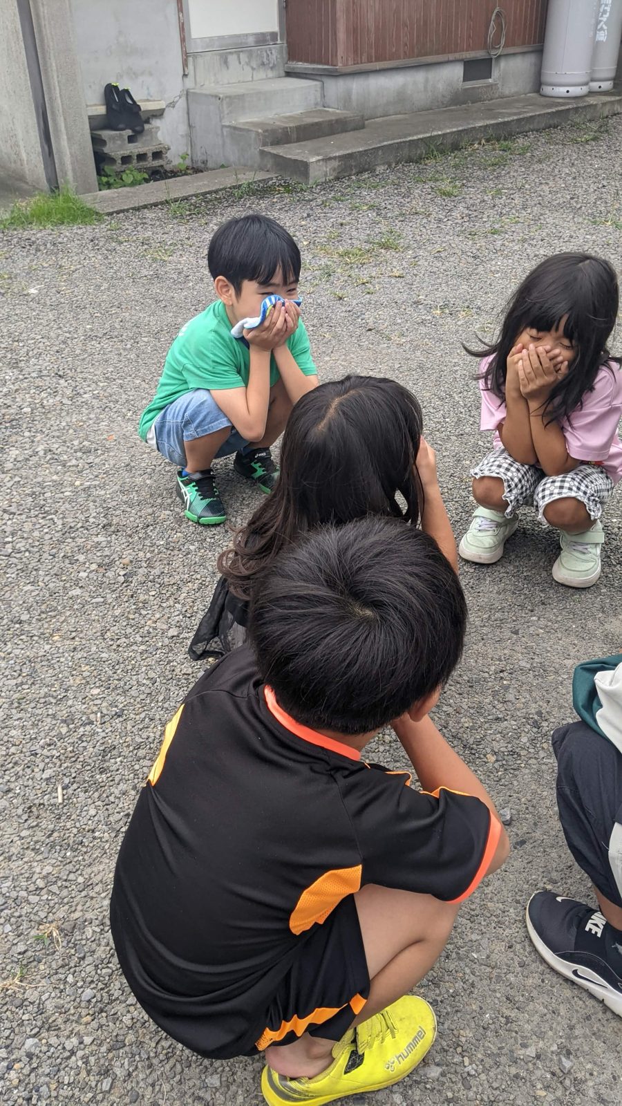 ハンカチや手で口元をおおいながら、しゃがんで避難する子どもたち